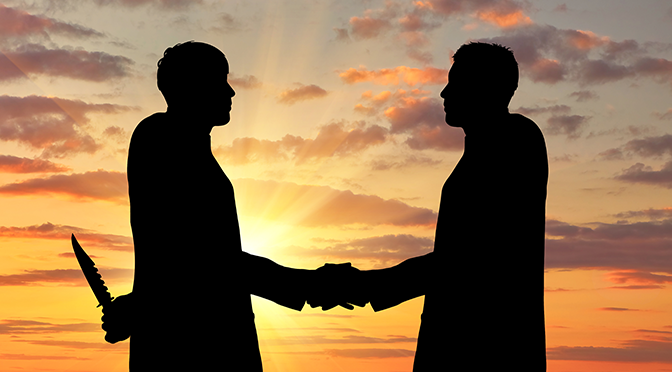 Concept of business betrayal. Silhouette of two businessmen shaking hands and keep arms behind his back weapon