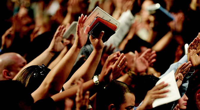Gottesdienst, erhobene Hände und Bibeln